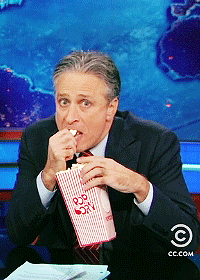 Jon-Stewart-Eagerly-Watching-Eating-His-Popcorn-On-The-Daily-Show.gif
